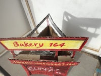 a cardboard model of a bakery with a sign on it