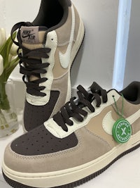 a pair of nike air force 1's in beige and brown