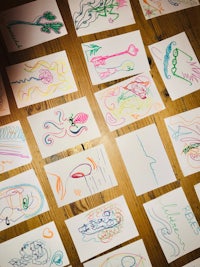 a group of children's drawings on a wooden table