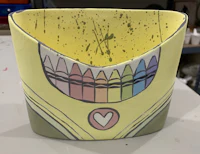 a yellow pot with crayons on it