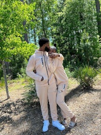 a man and woman hugging in the woods