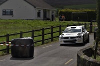a car driving down a road near a fence
