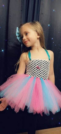 a little girl wearing a pink and blue tutu