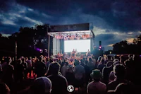 a crowd of people watching a concert on a stage