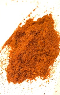 a pile of red powder on a white surface
