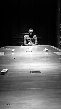 a black and white photo of a man sitting at a table