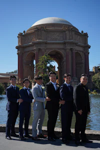 a group of men posing in front of a building