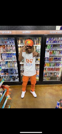 a man in an orange hat standing in front of a refrigerator