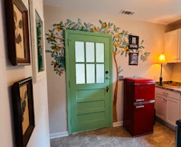 a kitchen with a refrigerator and a green door