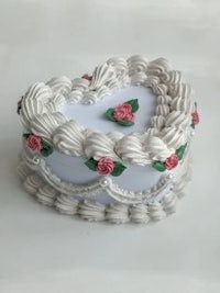 a white heart shaped box decorated with roses