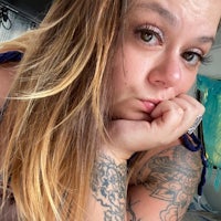 a woman with tattoos posing in a car