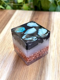 a square piece of glass with black and white stones on it