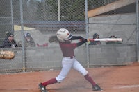 a softball player swinging a bat during a game
