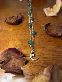 a necklace with a crescent and a moon on it