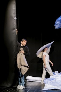 a group of people standing on a stage with paper in their hands