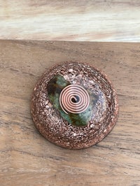 a stone with a spiral on it sitting on top of a wooden table