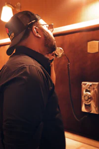 a man is talking on a phone in a bathroom