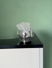 a silver disco ball sits on top of a desk