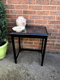 a black table with a plate on it next to a brick wall