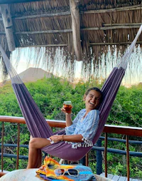 a woman relaxing in a hammock with a drink