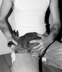a man with tattoos holding a rabbit