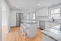a kitchen with white cabinets and stainless steel appliances