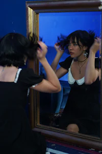 a woman is brushing her hair in front of a mirror