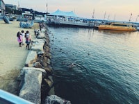 a group of people standing next to a body of water