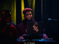 a dj with a laptop in front of a microphone