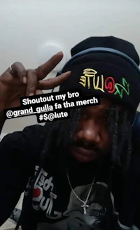 a man wearing a hat with the words shootout my bro grand ails feat the march