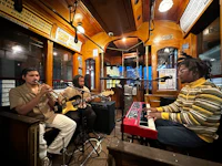 three men playing music on a trolley car