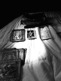 black and white photo of tarot cards on a bed