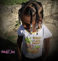 a little girl wearing a t - shirt with pineapples on it