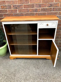 a white and wood bookcase with a glass door