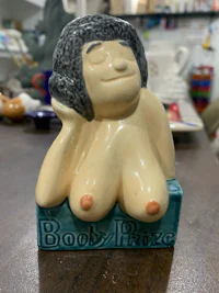 a statue of a naked woman sitting on a table