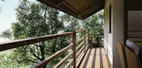 a balcony with a wooden railing overlooking a tree