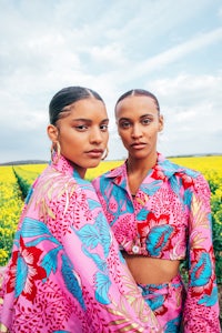 two women standing in a field of yellow flowers