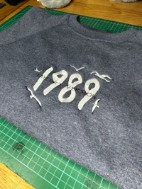 a grey sweatshirt with the word'1999'embroidered on it