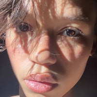 a close up of a woman's face with the sun shining on it