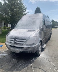 a mercedes sprinter is being washed on the street