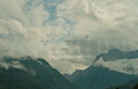 an image of mountains and clouds with a quote
