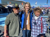 three people posing for a photo at an outdoor event