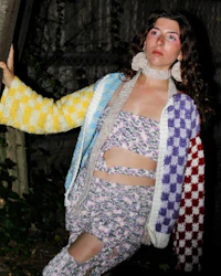 a young woman wearing a colorful knitted jacket