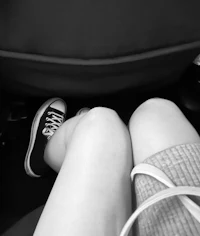 a black and white photo of a person sitting in a car