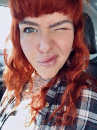 a woman with red hair and a plaid shirt