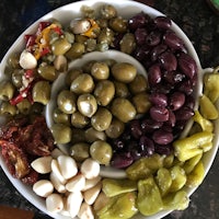 a plate full of olives, peppers, and other vegetables