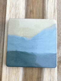 a ceramic coaster with a blue and tan design