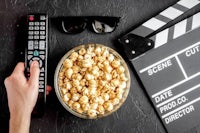 a bowl of popcorn and a remote control next to a movie clapper
