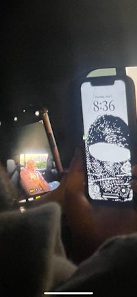 a person is holding a phone in the back seat of a car