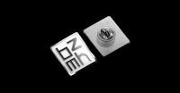 a pair of silver lapel pins on a black background